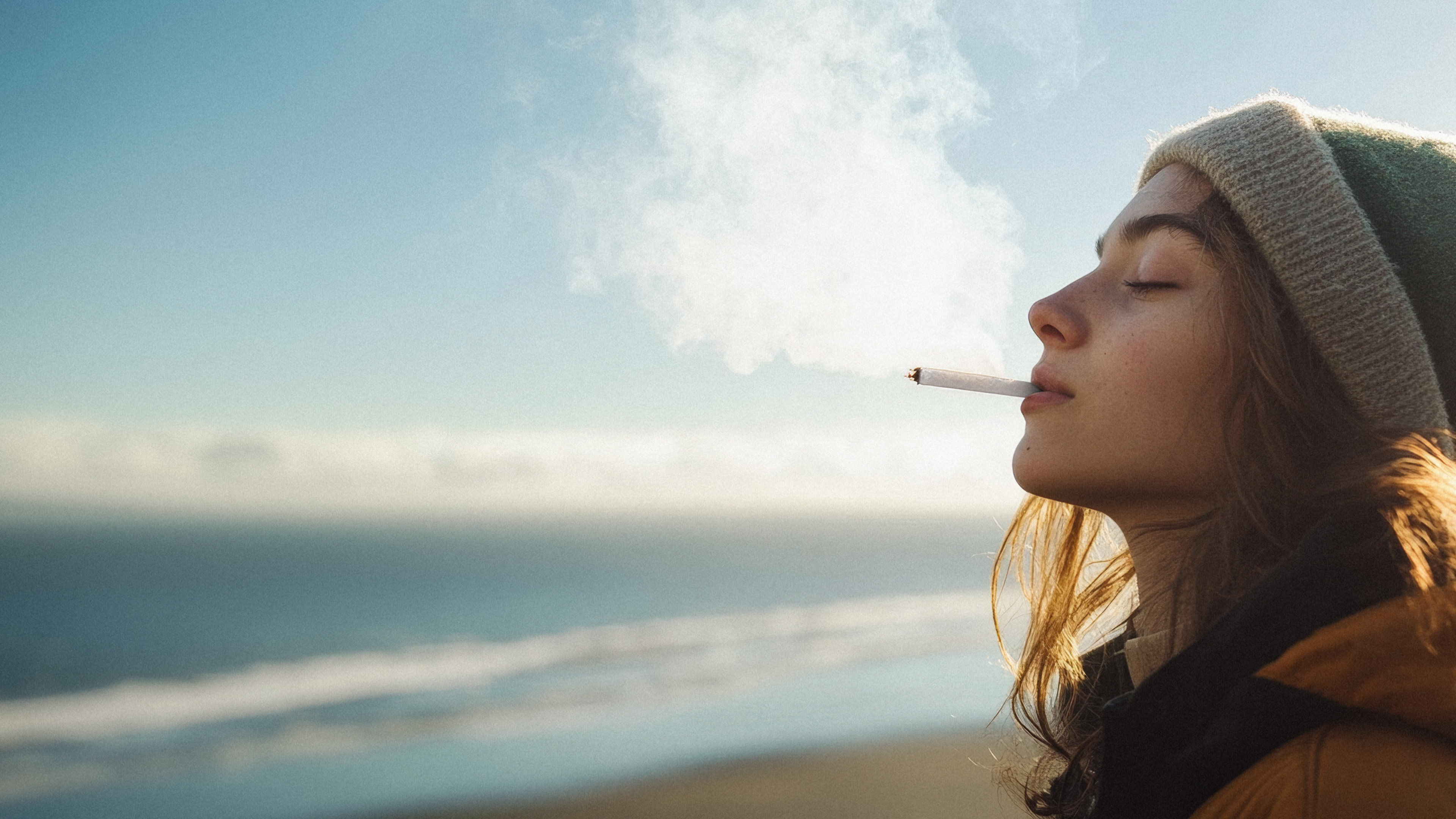 A hand holding a rechargeable vape unit in the woods.